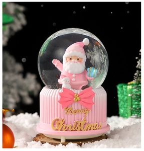 Close-up of pink Christmas musical snow globe with gold Merry Christmas text on base