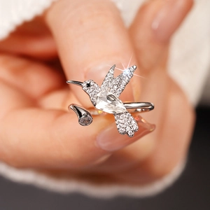 Detailopname van een kolibrie-ring met witte zirkonia en een peervormige edelsteen