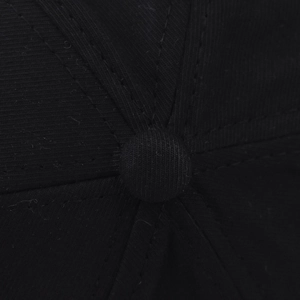 Macro shot of the top squatchee and stitched seams on a black cotton twill baseball cap