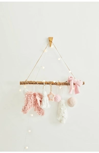 Hanging Christmas wall decor with warm LED lights, pink plush balls, and wooden stars