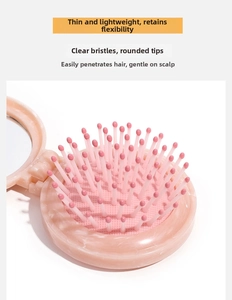 Detail view of pink marble folding hairbrush showing thin body and high-density massage bristles