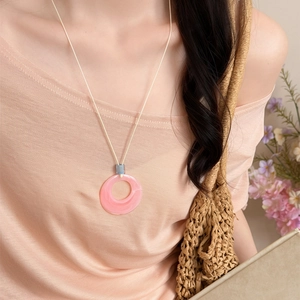 Close-up view of a sweet pink marble resin circle pendant necklace on a light cord
