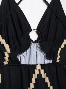 Détail d'une robe noire à imprimé géométrique beige et décolleté avec anneau métallique