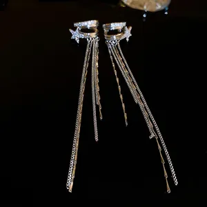 Orecchini a stella in argento con pavé di zirconi e lunghe catene su fondo nero