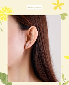 Close-up of S925 silver cat paw earrings with clear cubic zirconia on a model's ear