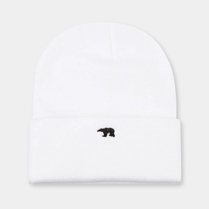 Dettaglio del berretto in maglia bianca con ricamo di orso nero di qualità sul risvolto