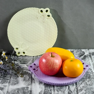 Dettaglio di vassoi in silicone a trama reticolare con rilievo a fiocco in beige e viola