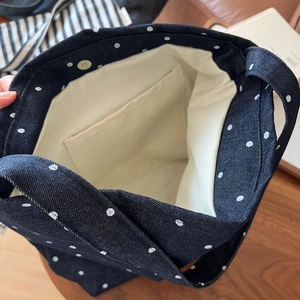 Inside view of polka dot denim tote bag showing magnetic clasp and canvas lining