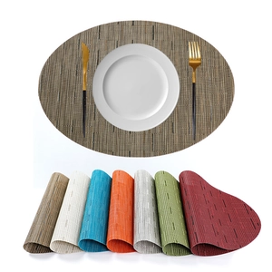Oval woven PVC placemats set in multiple colors with non-slip and heat-resistant texture