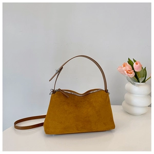 Close-up of ginger suede texture and silver hardware on a minimalist shoulder bag