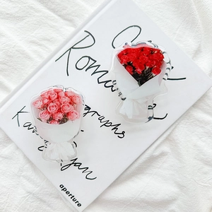 Detail view of pink and red rose flower acrylic phone grips on a minimalist book