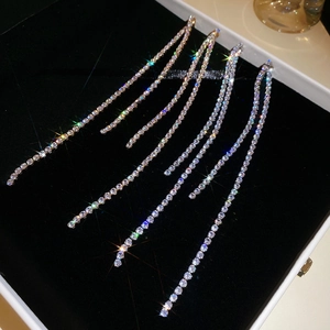 Macro shot of long silver tassel earrings with zircon stones on a black velvet box