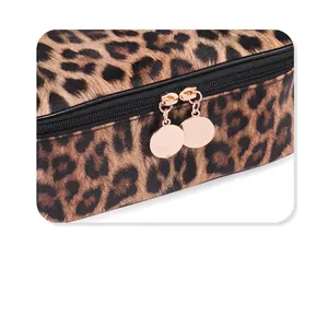 Detail shot of leopard print makeup bag featuring gold round metal zippers and black teeth