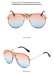 Detail view of aviator sunglasses with gold frame, bee emblem and orange-blue gradient lenses
