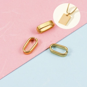 Polished gold stainless steel pinch bails and pendant connectors on marble surface