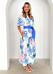 Floral A-line dress with puff sleeves and blue sash belt against arched background