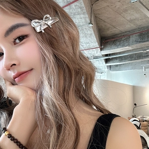 Barrette à cheveux nœud en strass étincelants avec bord argenté sur cheveux ondulés