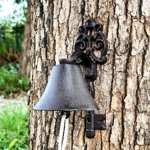 Vintage cast iron garden bell with ornate scroll bracket and white cotton pull rope