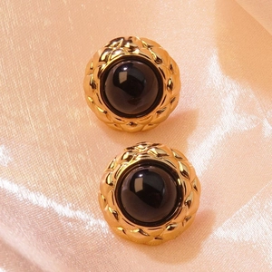 Detailed view of vintage black gold button earrings with classic quilted lattice metal texture