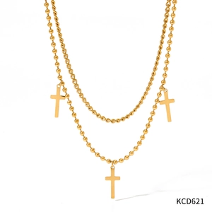 Detailansicht der goldene Doppel-Halskette mit Kordelkette und Kreuz-Anhängern