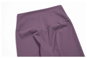 Detail of high-waisted purple yoga leggings featuring V-shaped seams and brushed fabric