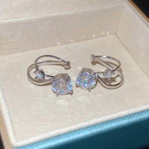 Macro detail of silver geometric ear cuffs with zircon stones on jewelry box