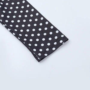 Détail de la manchette à double couture d'un haut à manches longues à pois noir et blanc