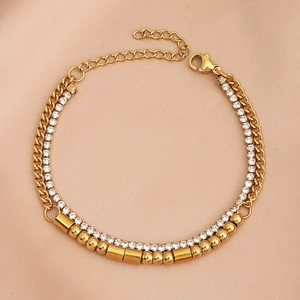 Detail of double-layer gold stainless steel bracelet with crystals on champagne silk