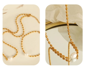 Detail view of gold olive bead necklace with irregular pearl on white silk background