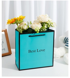 Detail of teal gift bag with Best Love text and black nylon rope handles for gifting