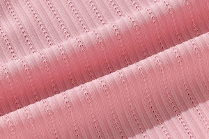 Gros plan sur un tissu en dentelle rose respirant avec rayures verticales et tricot ajouré