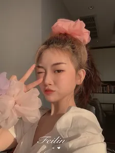 Close-up of oversized organza scrunchies in pink and lavender worn as trendy hair accessories