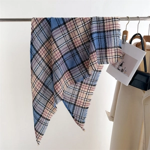 Detail of blue and pink plaid scarf with fringe tassels hanging in a stylish setting