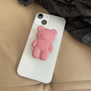 Close-up of pink frosted bear phone grip stand on a white smartphone back cover