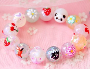 Vue macro de perles en acrylique peintes à la main avec motifs cartoon sur dentelle