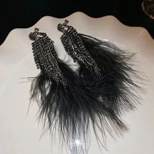 Gothic style black feather tassel earrings with sparkling rhinestones and beaded details