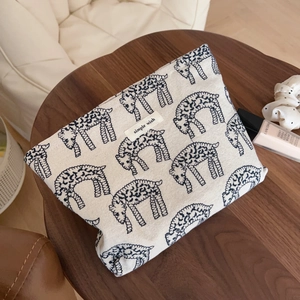 Retro canvas makeup bag with blue sheep print and simple wish label on a wooden table