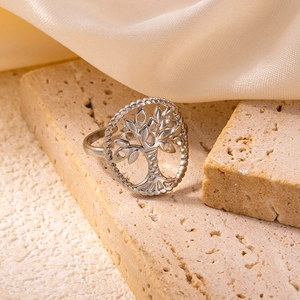 Polished silver stainless steel tree of life cutout ring on natural stone base