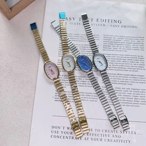 Flat lay of oval dial quartz watches with metal strap in four assorted colors