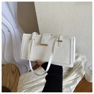Detail of white crocodile pattern shoulder bag with elegant golden metal flip clasp