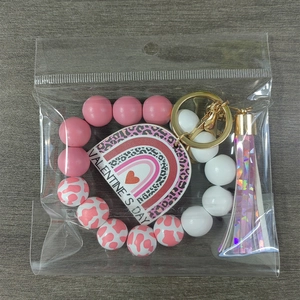 Detail of Valentine's day keychain with pink wood beads and heart leopard print charm