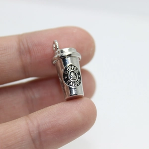 Detailed close-up of a silver coffee cup pendant with Coffee Coffee engraved text