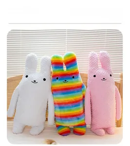 Detailed view of striped long rabbit plush pillows on bed with soft textured fabric
