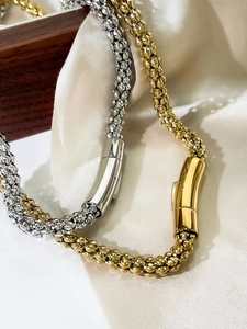 Detailed macro view of 6mm gold and silver snake chains with polished cylindrical clasps
