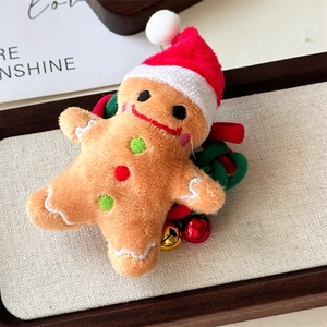 Detail of plush gingerbread man hair tie with Christmas hat and small festive bells
