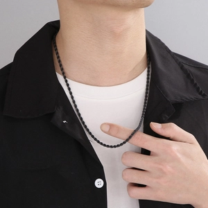 Close-up of black twisted rope chain necklace worn on model for a trendy metal texture