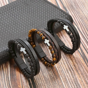Detail of multi-layer natural stone bracelets with leather bands and steel cross charms