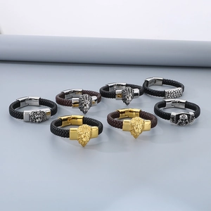 Detailed view of men's woven leather bracelets with lion and skull metal charms