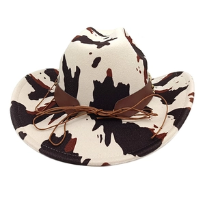 Close-up of cow print cowboy hat with dark brown leather band and intricate knot detail