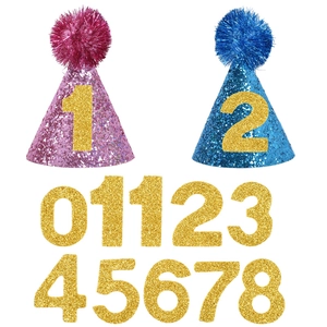 Detail of glitter party hats in pink and blue with DIY golden age number stickers